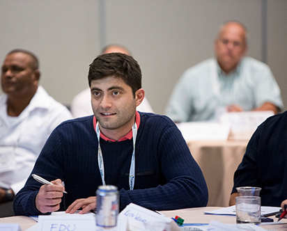 man in blue sweater smiling at a respect for people event